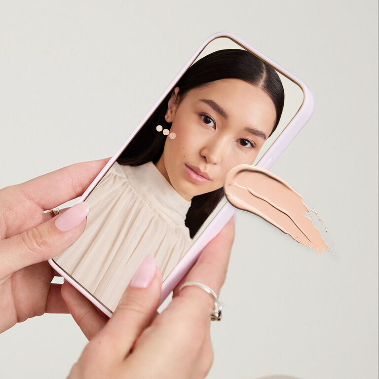 Manos sosteniendo un dispositivo m&oacute;vil que muestra la herramienta Mary Kay Tu Base Ideal.
