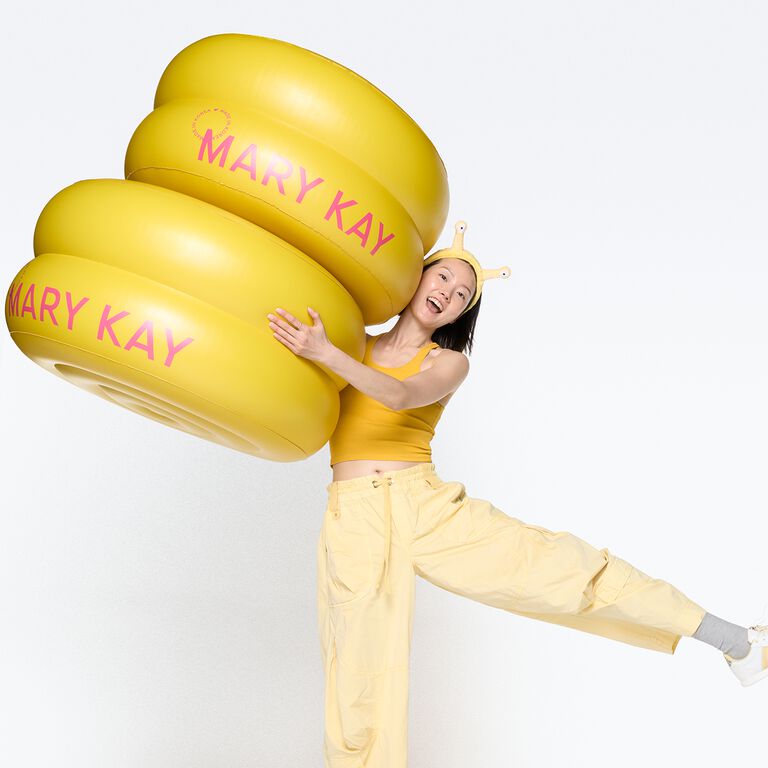 Mujer abrazando un inflable de Parches Faciales con Gel de Caracol Mary Kay&reg; de Edici&oacute;n Especial