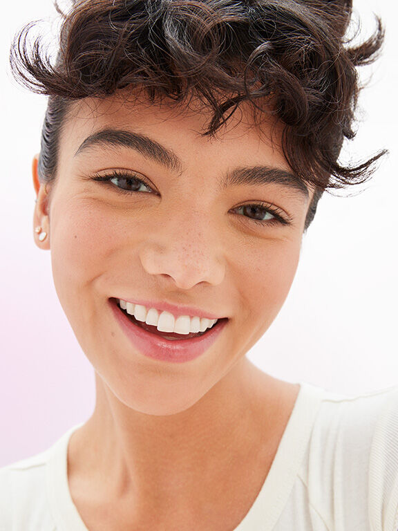 Mujer morena con tono de piel medio usando maquillaje natural.