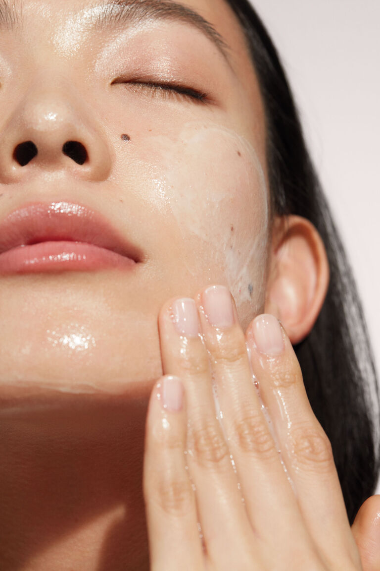 Acercamiento al rostro de una muejer aplic&aacute;ndose la Limpiadora Facial 4 en 1 TimeWise&reg;.