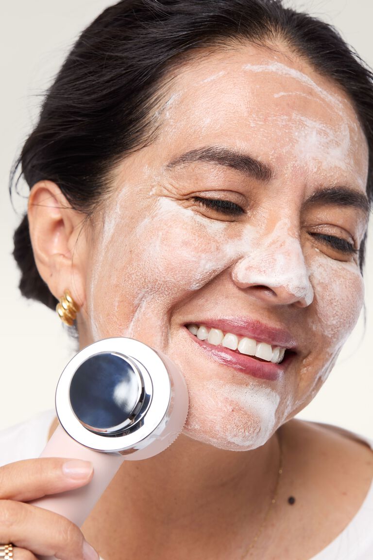 Mujer limpiando su rostro con Skinvigorate Duo y producto Mary Kay