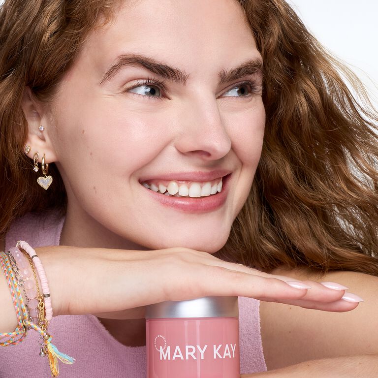 Mujer sonriendo sosteniendo un frasco de Gel Humectante con Col&aacute;geno Mary Kay&reg; de Edici&oacute;n Especial cerca del rostro