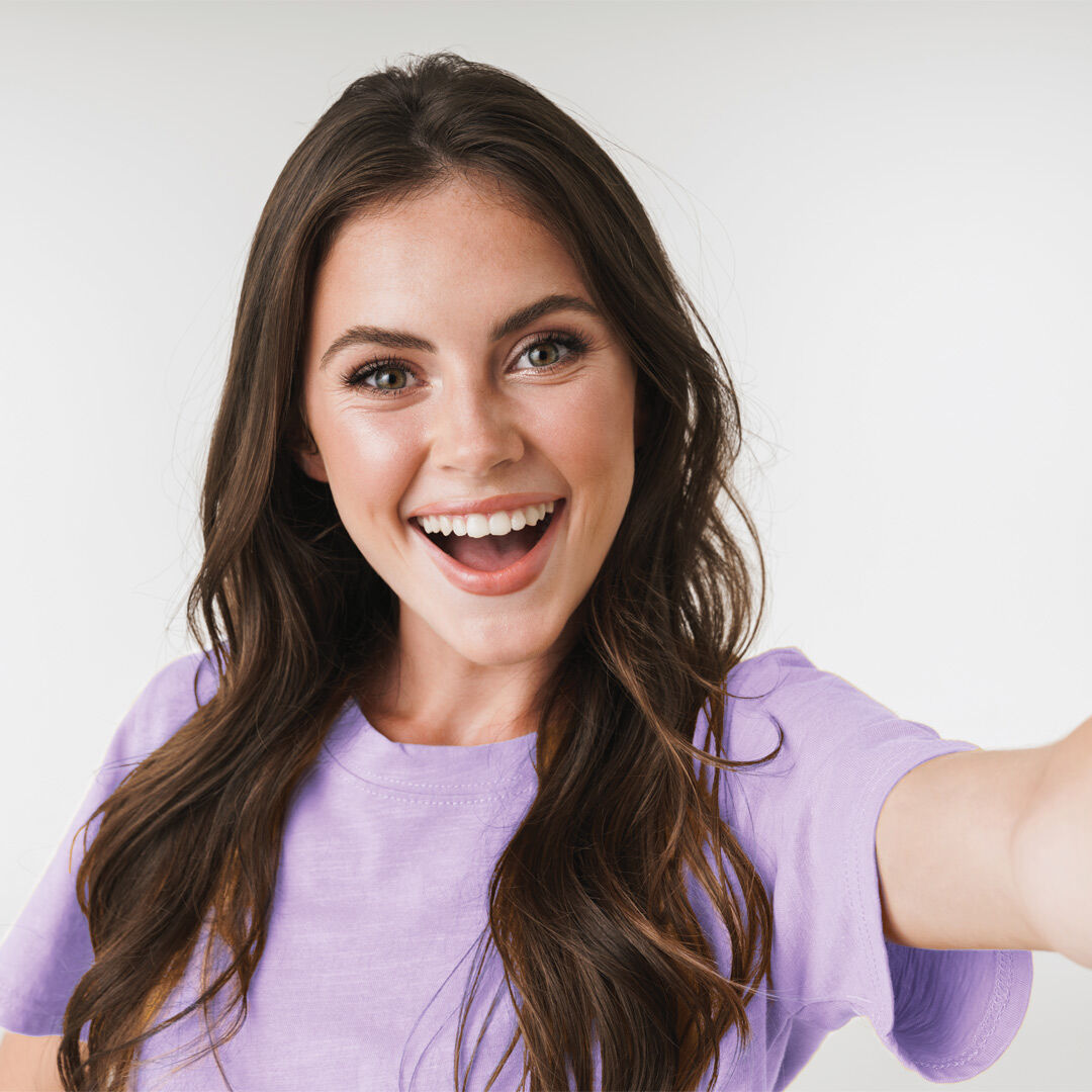 Mujer sonriendo mientras se toma una selfie