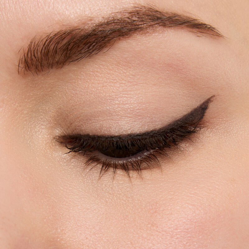 Macro of Mary Kay Matte Eye Shadow Stick in Black Obsidian on light skin tone used as eyeliner