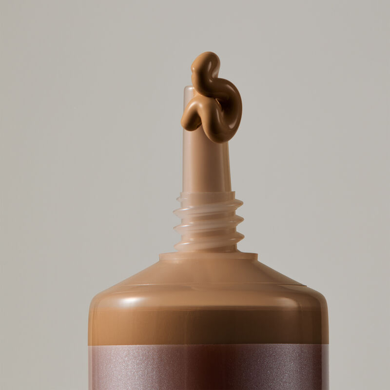 Macro view of TimeWise Matte 3D Foundation needle-nose applicator dispensing Deep 2 shade