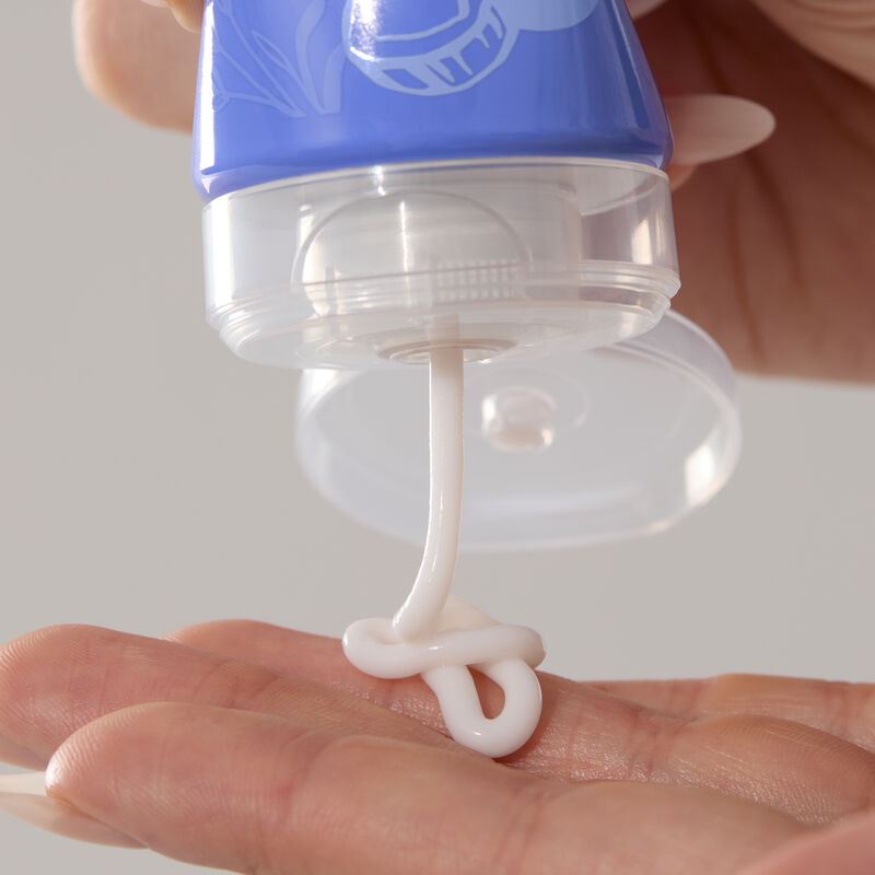 Close-up of hand cream being squeezed from its tube onto fingers.&nbsp;&nbsp;