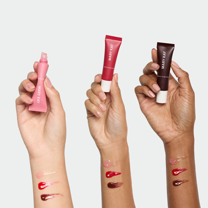 All three shades of Tinted Lip Butter held up by light medium and deepskintoned arms with color swatches on wrists