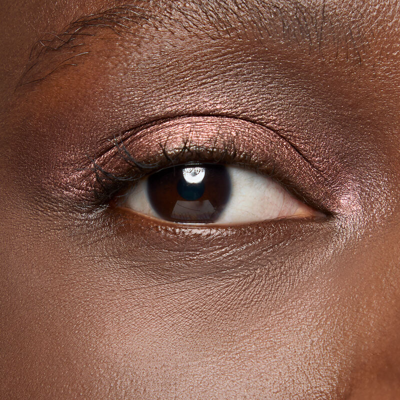 A model with a deep skin tone and brown eyes wears shade Radiant Bronze.&nbsp;