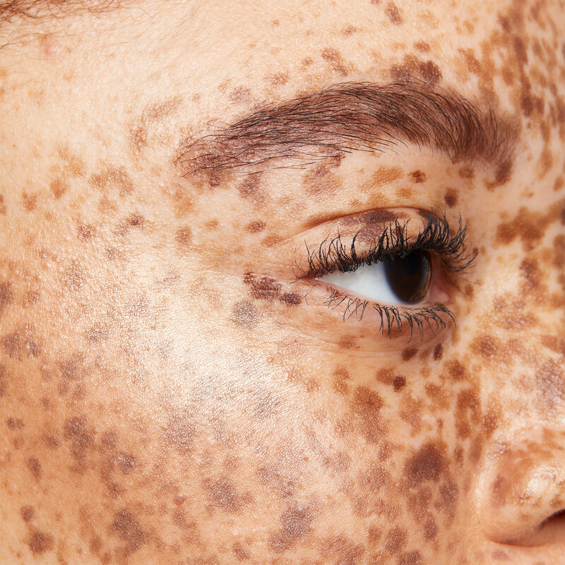 Close up of medium-skinned model with reddish brown hair, brown eyes and many freckles wearing limited-edition Mary Kay Illuminating Bronzer