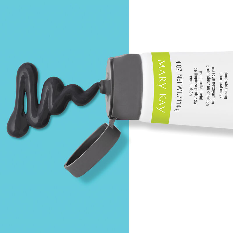 The Mary Kay Clear Proof Deep Cleansing Charcoal Mask pours out of its bottle and rests atop a turquoise blue background.