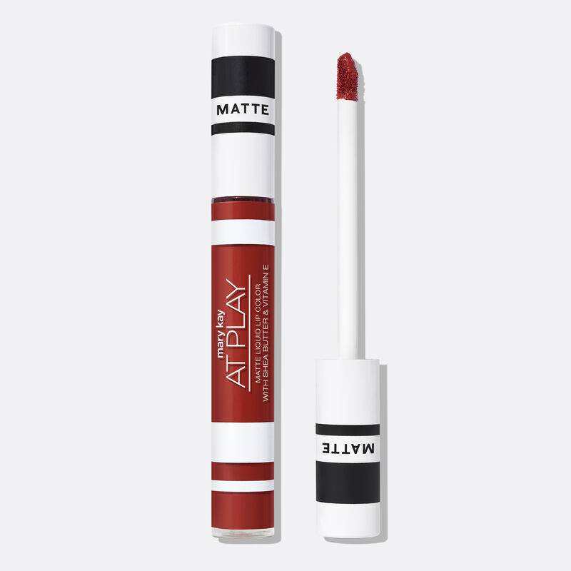 Closed tube of Mary Kay At Play Matte Liquid Lip Color in shade Red My Mind next to accompanying applicator