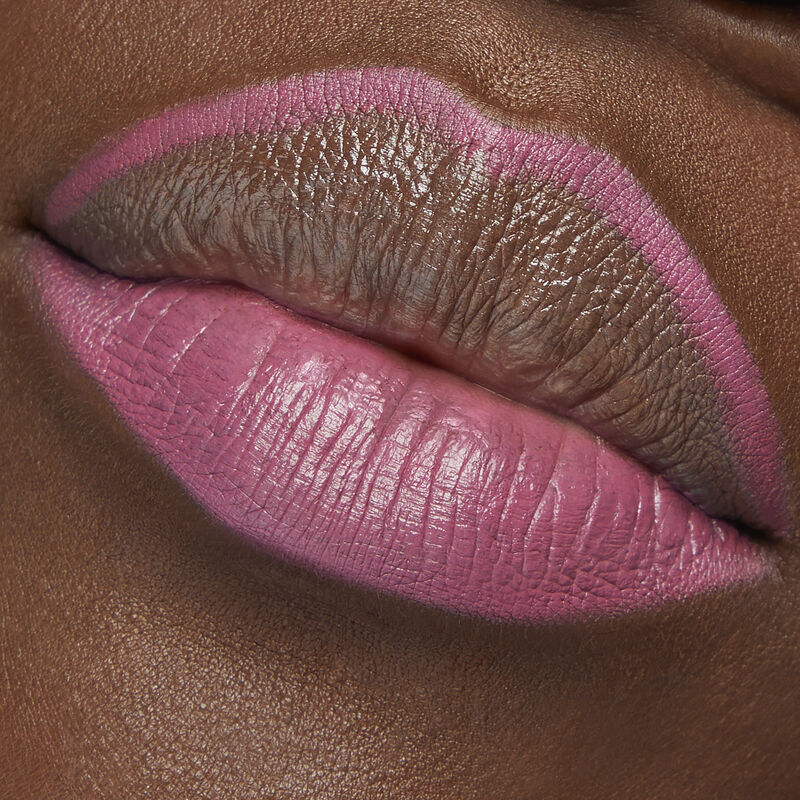 Close up of deep-skinned model with special-edition Mary Kay Waterproof Lip Liner in shade Violet Lilac outlining top lip and filling bottom lip