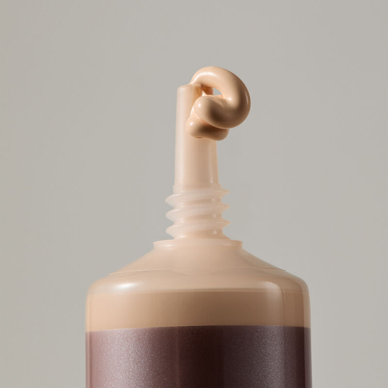 Macro view of TimeWise Luminous 3D Foundation needle-nose applicator dispensing Light 7 shade