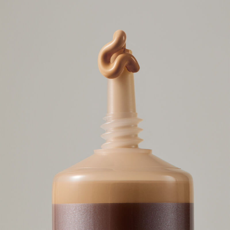 Macro view of TimeWise Matte 3D Foundation needle-nose applicator dispensing Medium 1 shade