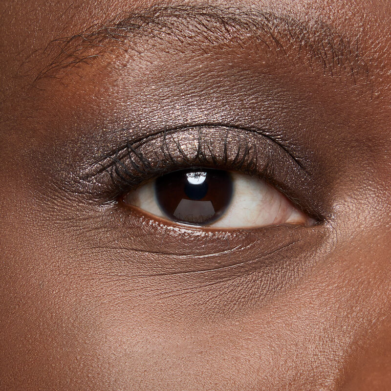 A model with a deep skin tone and brown eyes wears shade Midnight Galaxy&nbsp;