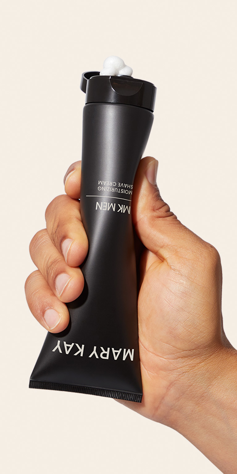 Mano presionando un tubo de la Crema de Afeitar 2 en 1 MK Men&reg; mostrando el producto.