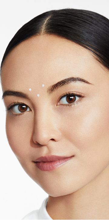 Aplicaci&oacute;n de tres puntos de Crema Efecto Rellenador de Arrugas Volu‑Fill&reg; TimeWise&reg; Repair cerca de las cejas.