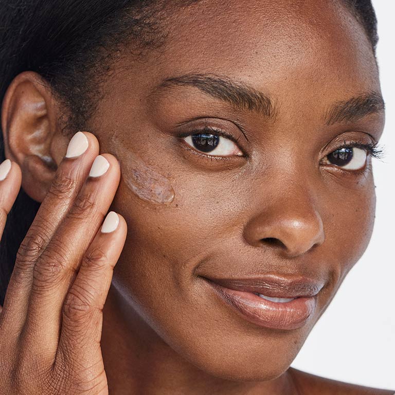 Mujer con tono de piel morena aplic&aacute;ndo Gel Corporal Restaurador para Despu&eacute;s de Asolearse Mary Kay&reg; en su mejilla