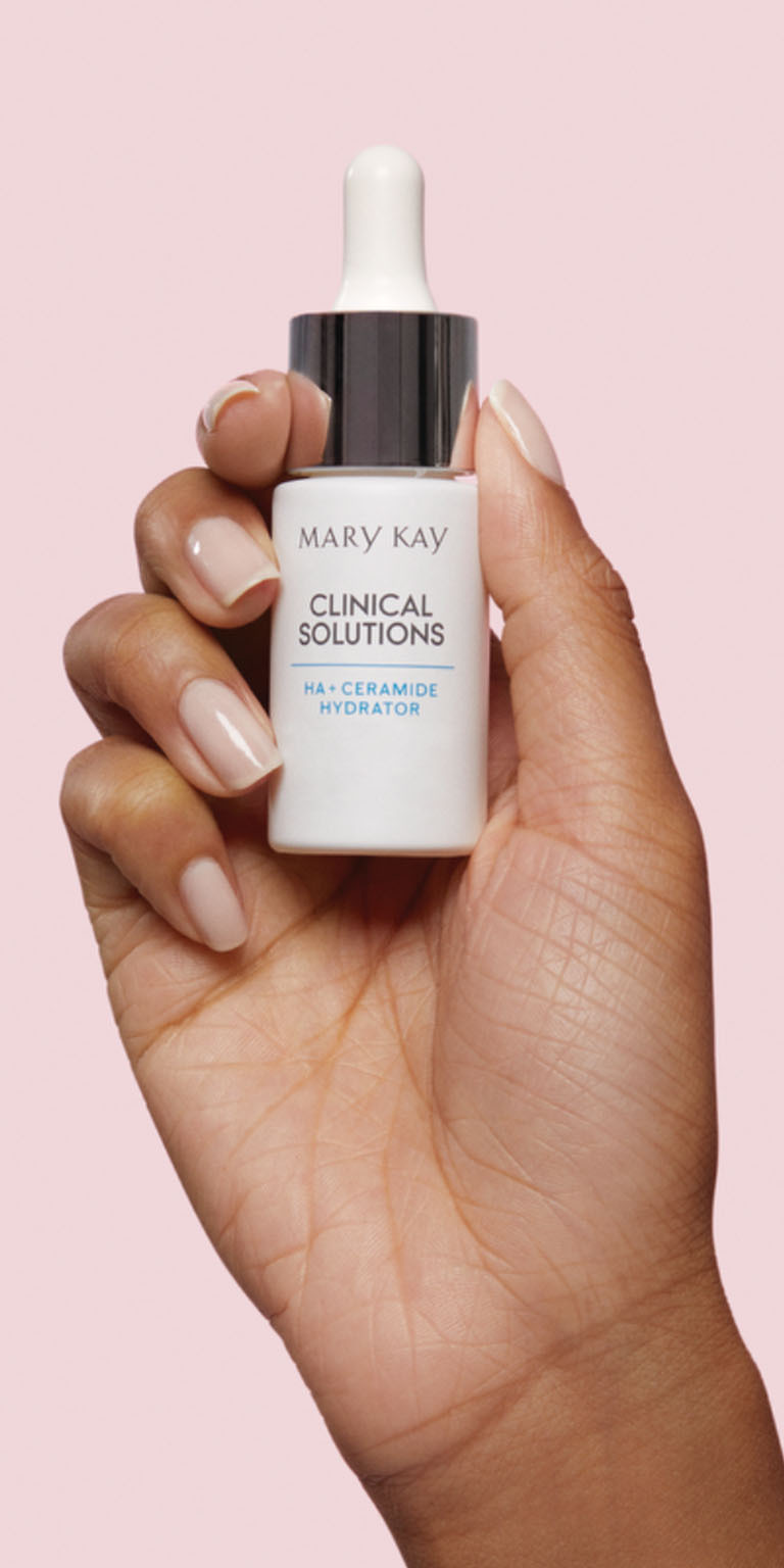 Modelo sosteniendo el frasco de Concentrado HA + Ceramida para la Humectaci&oacute;n Mary Kay Clinical Solutions&reg; sobre un fondo rosa