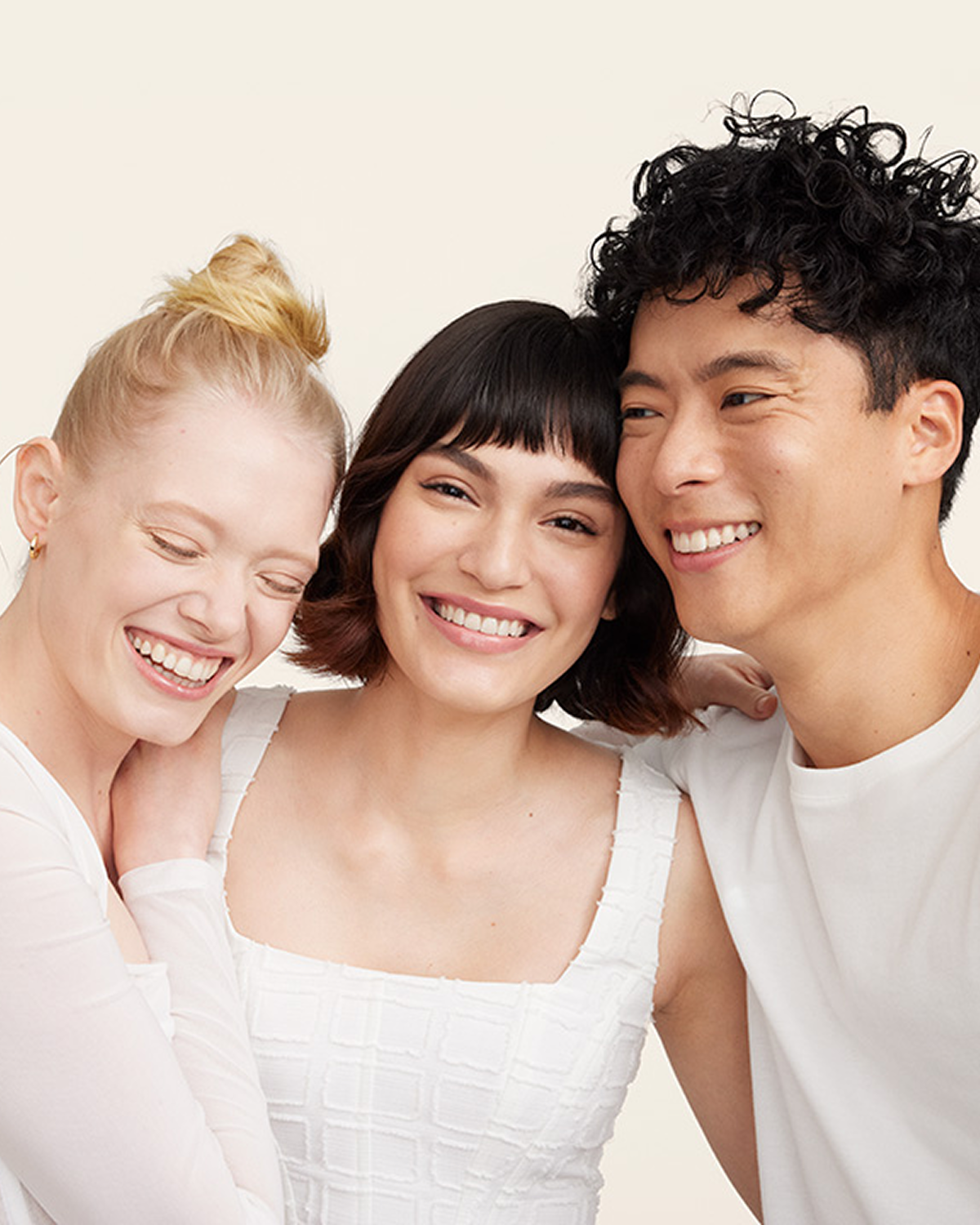 Tres personas abrazadas riendo