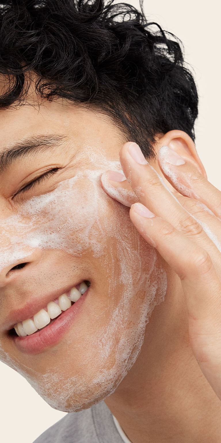 Modelo masculino aplicando el Gel Limpiador Facial MK Men&reg; en el costado de su rostro